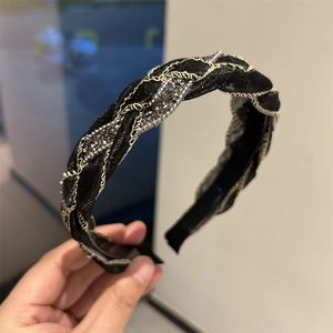 Dettaglio del cerchietto in seta nera intrecciata con strass argentati brillanti