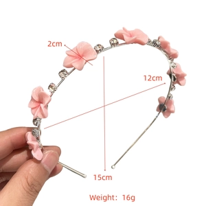 Détail d'un serre-tête fleurs roses avec cadre argenté et strass brillants 15x12cm