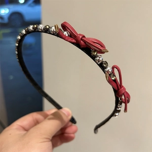 Sparkling rhinestone bow headband with red leather accents and metallic beaded trim