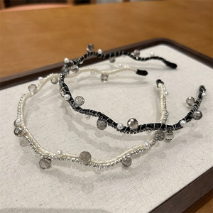 Close-up of black and cream woven headbands with crystals, pearls and rhinestones