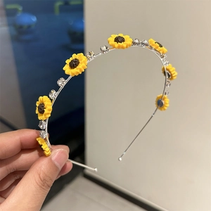 Détail d'un serre-tête argenté avec fleurs de tournesol et strass brillants et élégants