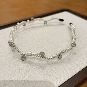 Detailed close-up of woven headband with pearls, grey crystals, and sparkly rhinestones