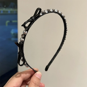Close-up of black leather headband featuring delicate bows and sparkling rhinestones