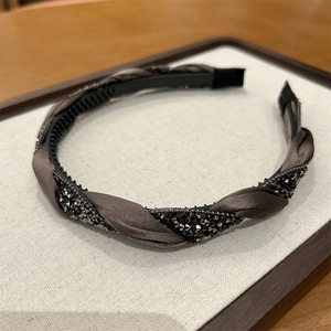 Detail of braided dark brown fabric headband with sparkling grey crystal embellishments