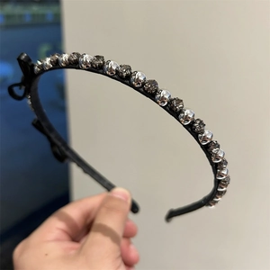 Detail view of a black bow headband with sparkling silver rhinestones for women