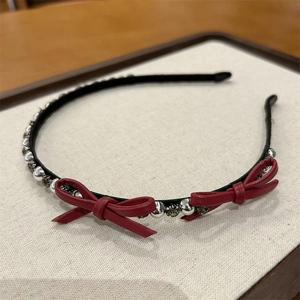 Detail showing red leather bows with silver beads and grey crystals on a slim headband