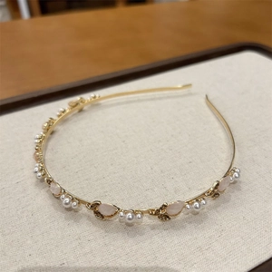 Dettaglio del cerchietto a tulipano con pietre d'ibisco e perle su metallo dorato