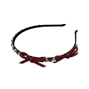 Sparkling rhinestone bow headband with red leather accents on a sleek black frame