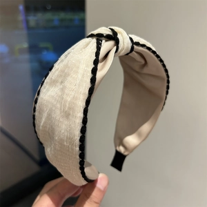 Classic beige and black knot headband with woven trim detail in stylish fabric