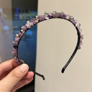 Dettaglio di un cerchietto fatto a mano con cristalli viola e perline sfaccettate