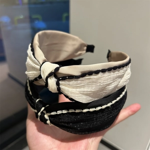 Chic knotted wide headband in black and white with contrast woven trim for women