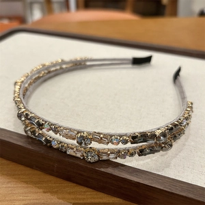 Close-up of double-layer crystal headband with gold base and sparkling zircon detail