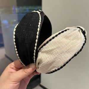 Detail of Korean style wide fabric headbands featuring contrast stitching and woven texture