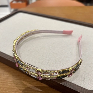 Detail of double-layer gold headband with pink crystal zircons on a white display