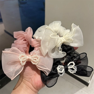 Close-up of three pieces set tulle hair scrunchies with elegant pearl bow design
