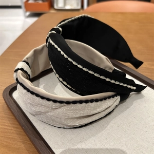 Detail of twisted knot headbands featuring contrast stitching and soft satin texture
