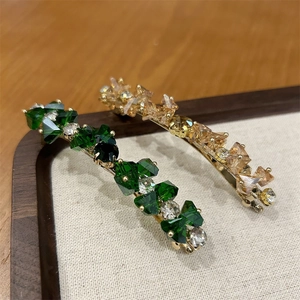 Set di fermagli per capelli dorati con cristalli verdi e champagne su vassoio