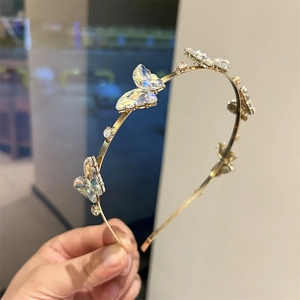 Détail du serre-tête doré orné de papillons en cristal violet et de petits diamants brillants