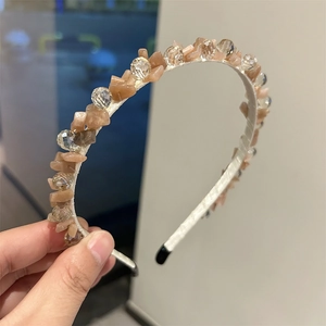 Dettaglio delle perle di cristallo color pesca e pietre trasparenti fatte a mano sulla fascia