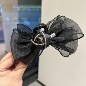 Pince à cheveux élégante avec nœud en tulle noir, rose en strass et détail logo en métal