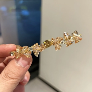 Dettaglio del fermaglio per capelli fatto a mano con cristalli champagne e oro