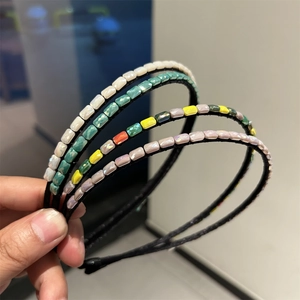 Detail of four handmade crystal headbands with colorful faceted beads on slim black frames