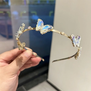 Gros plan de papillons en verre irisé avec strass sur un serre-tête doré métallique