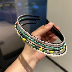 Close-up of handmade beaded headbands with faceted crystals in various colors on black frames