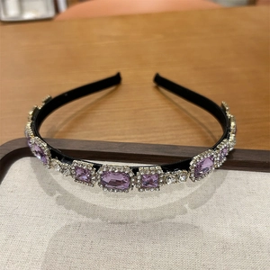 Close-up of vintage rhinestones on a French-style headband with purple and clear crystals