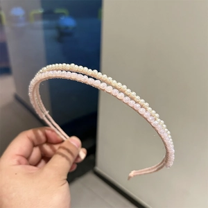 Detail of double-layer headband featuring white pearls and pink crystal beads on a pink frame