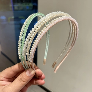 Detail view of four elegant beaded headbands with faux pearls and crystals in soft colors