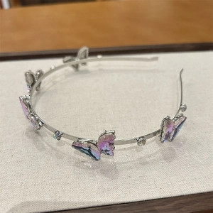 Détail d'un serre-tête argenté orné de papillons en verre violet dégradé et de cristaux