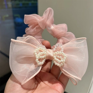 Detailed shot of pink organza scrunchie with oversized mesh bow and pearl butterfly detail
