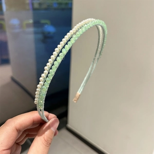 Close-up of double-layer headband with white pearls and light green crystal beads