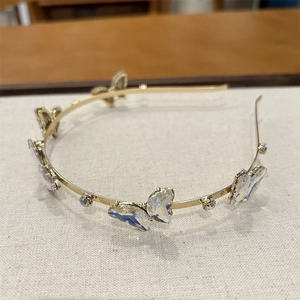 Vue détaillée du serre-tête doré orné de papillons en cristal violet irisé et de strass
