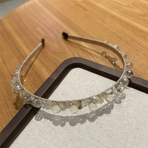 Dettaglio di un cerchietto in cristallo fatto a mano con perle scintillanti e champagne