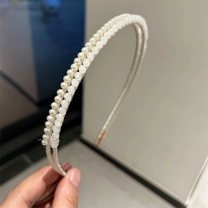 Detail of elegant double-layered headband with white faux pearls and clear crystal beads