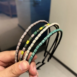 Close-up of thin hairbands with faceted rectangle beads in gray-purple and teal colors