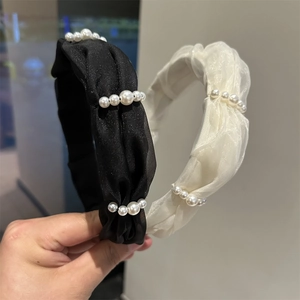 Close-up of pleated chiffon headbands with gradient imitation pearls in black and beige