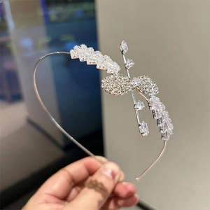 Gros plan sur un serre-tête étincelant en zircone avec motifs de feuilles et fleurs en cristal