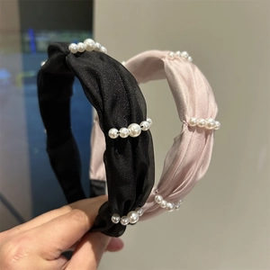 Detail of satin twisted headband with pearl embellishments in black and pink colors
