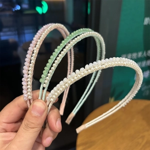 Macro detail of slim pearl and crystal beaded headbands in pastel pink and green