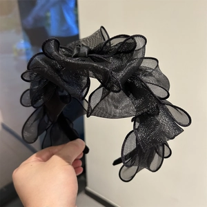 Dettaglio del cerchietto intrecciato nero in tulle con ruches multistrato e glitterini