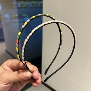 Detail of handmade thin headband with colorful acrylic beads and fishline wrap craft
