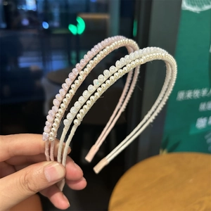 Detailed macro view of four slim pearl and crystal beaded headbands for women