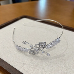 Détail d'un serre-tête papillon en zircon étincelant avec cadre en métal argenté poli