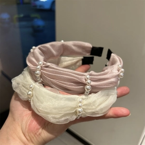 Detail of pink satin and white gauze headbands decorated with elegant white pearls