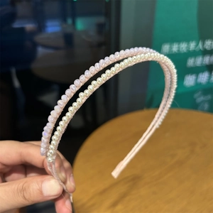 Detail of a double-layered headband featuring faux pearls and pink crystal beads on silk fabric