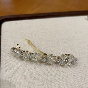 Dettaglio dell'elegante fermaglio per capelli dorato con cristalli trasparenti