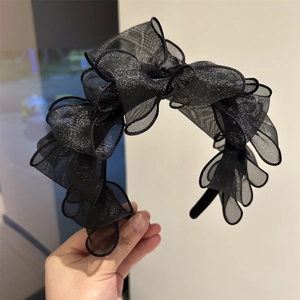 Dettaglio del cerchietto in mesh nero a più strati con texture glitterata e volant chic